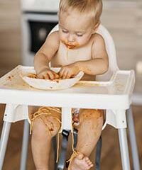 Bébé qui touche et explore ses aliments avec les mains