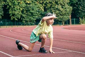 Enfant sur une ligne de départ, illustrant l'effort supplémentaire lié aux réflexes immatures